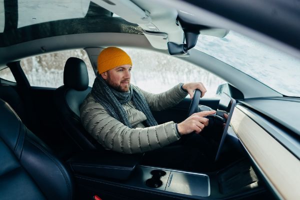 man wearing winter clothes driving