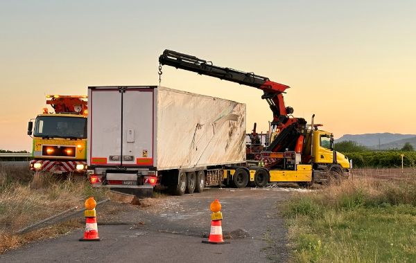 Recovery Truck Tows a Semi trailer truck after crash.