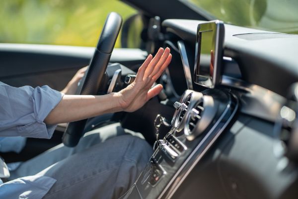 Womans hand outreached to feel air from vehicle vents