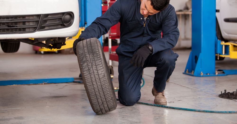 Expert repair man looking at a tire in a general repair shop