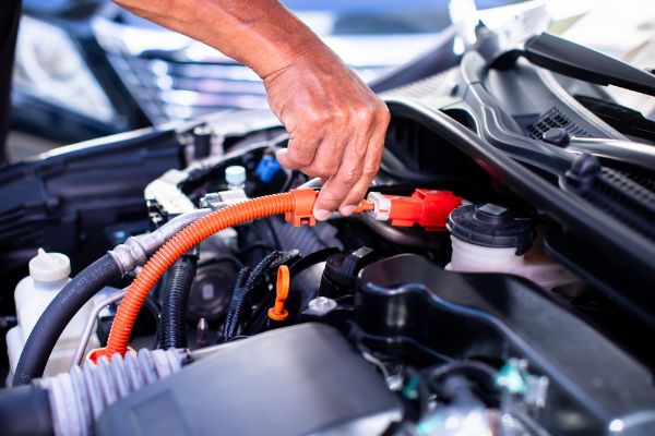 Mechanic's hands are checking engine equipment for a Hybrid Plug-in vehicle