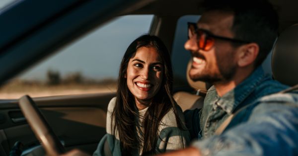 Two people happy inside their vehicle while driving