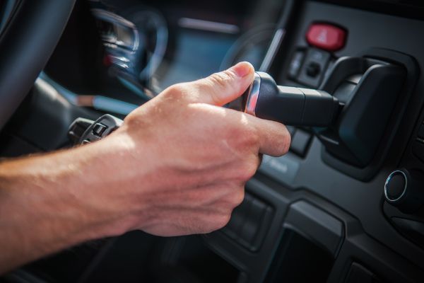 Semi Truck Air Brake Releasing by Caucasian Driver. Vehicle Interior Closeup Photo