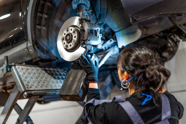 mehanic inspecting brakes on a vehicle