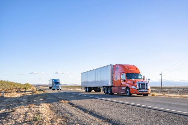 Industrial long hauler big rigs semi trucks team transporting commercial cargo