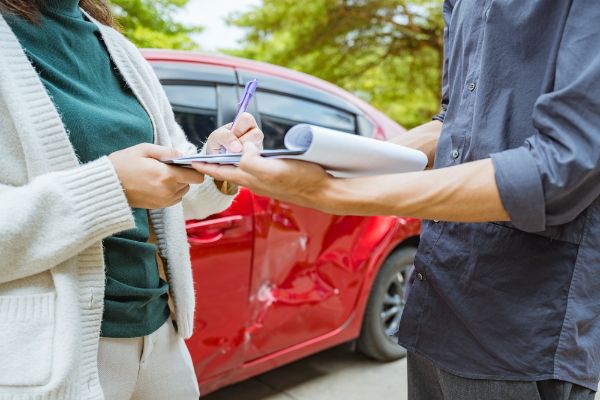 Auto body technicians assisting a customer with a insurance claim