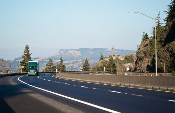 Semi truck driving up a road in the mountains