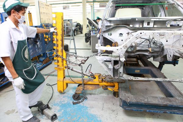 Car Frames repair Straighten and pulling , Repairman wearing protective equipment