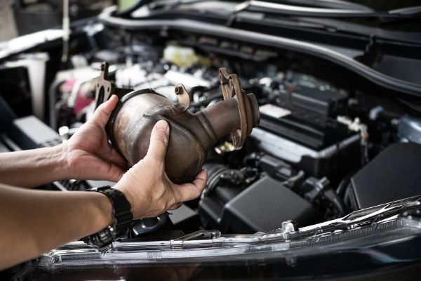 Close up old catalytic converter in hand Car service staff