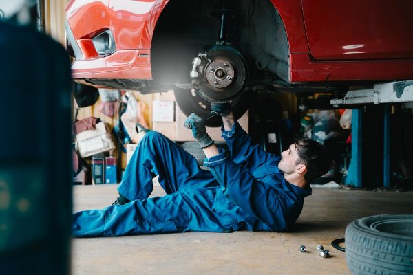 mechanic working on car brakes