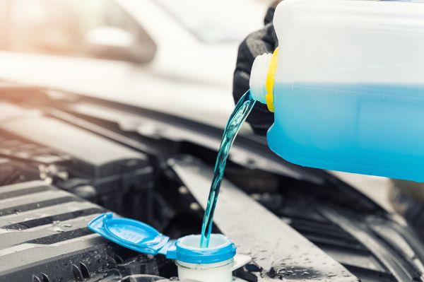 Mechanic conducting a antifreeze service on a vehicle