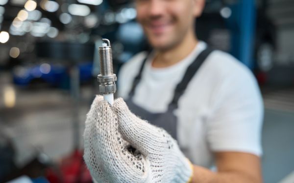 mechanic holding spark plug