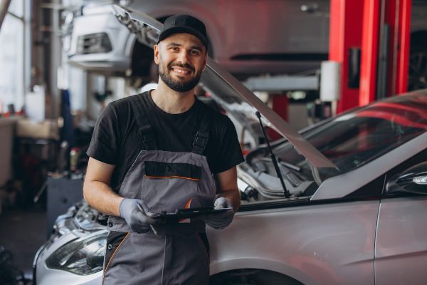 mechanic happily performing general auto repair