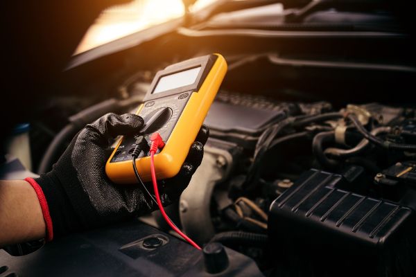 Mechanic checking auto electrical issues on a vehicle