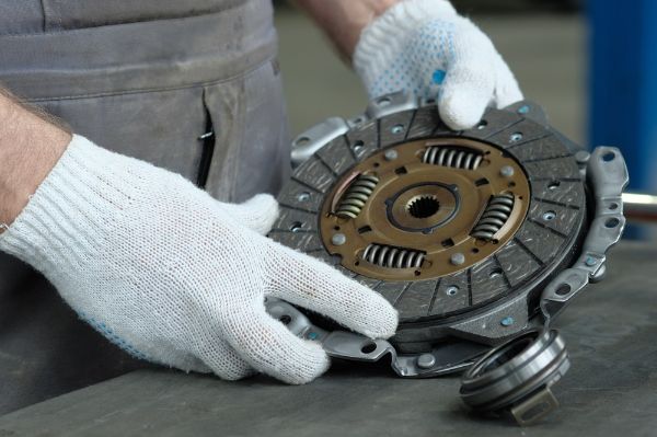 An auto mechanic performs a clutch replacement on a vehicle