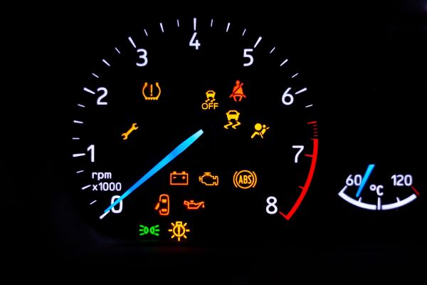 A car's dashboard lights up with multiple alert icons, signaling various vehicle functions