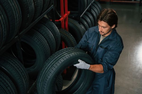 Mechanic pulling a new tire for a replacement