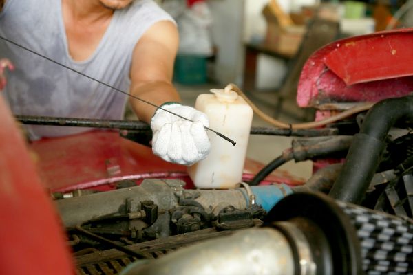 Close-Up Of man Checking Car Engine Oil Level On Dipstick