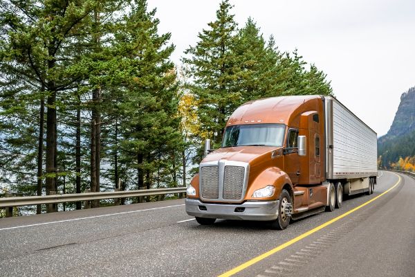 Industrial brown big rig long haul semi truck, truck driver transporting cargo