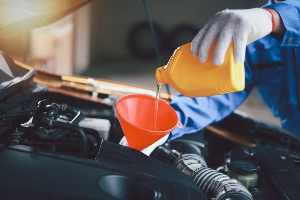Close up of mechanic pouring oil