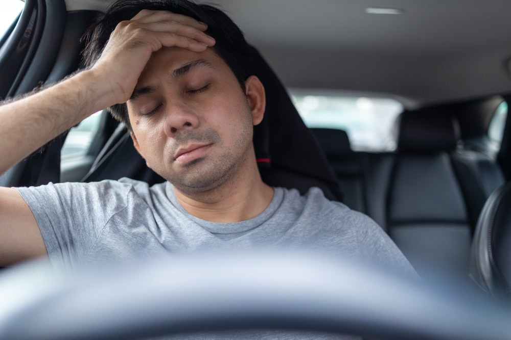 man feeling stressed in a car from transmission failure