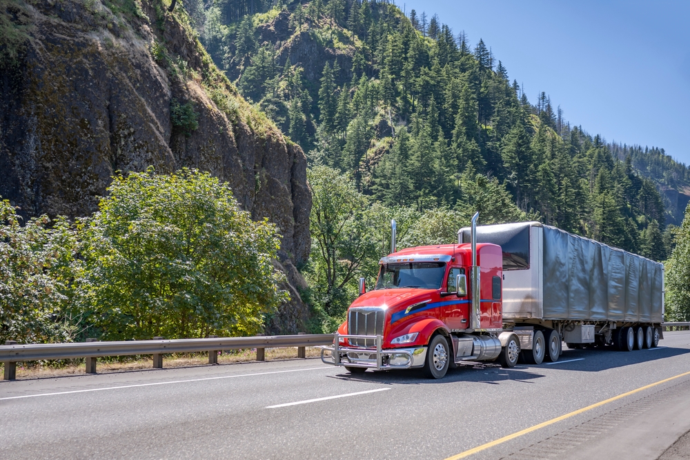 red semi truck driving up mountain road