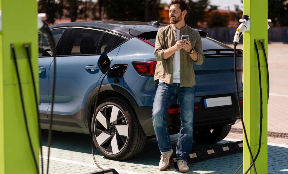 man charging electrical vehicle